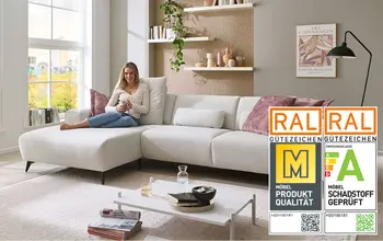 Frau sitzt auf gemütlichen weißem Sofa und entspannt.